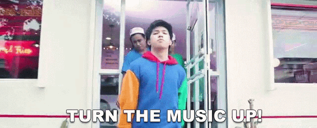 a man is standing in front of a door with the words turn the music up written on it