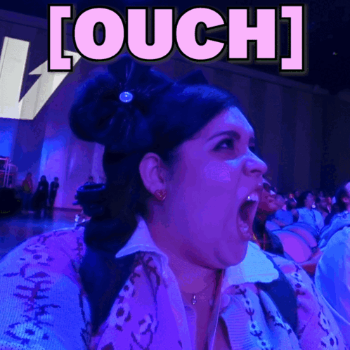 A woman reacts loudly in purple-blue lighting beneath “[OUCH]” text.