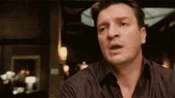 A man looks startled and confused in a dim restaurant scene.