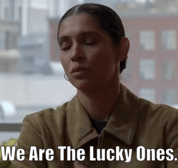 a woman sitting in front of a window with the words we are the lucky ones written on her face