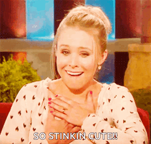 Kristen Bell smiles warmly with her hands near her chest under “SO STINKIN CUTE.”