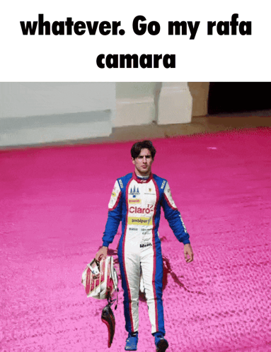 a man in a racing suit is holding a helmet and says whatever go my rafa camara on the bottom