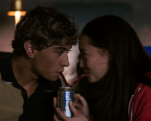 a man and a woman drinking from a blue ribbon soda can