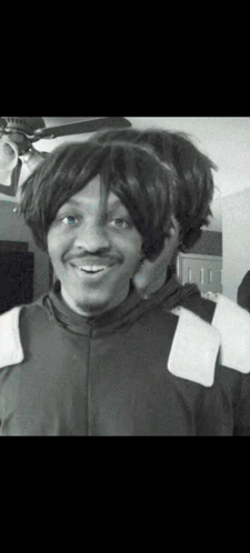 a black and white photo of a man with a wig on