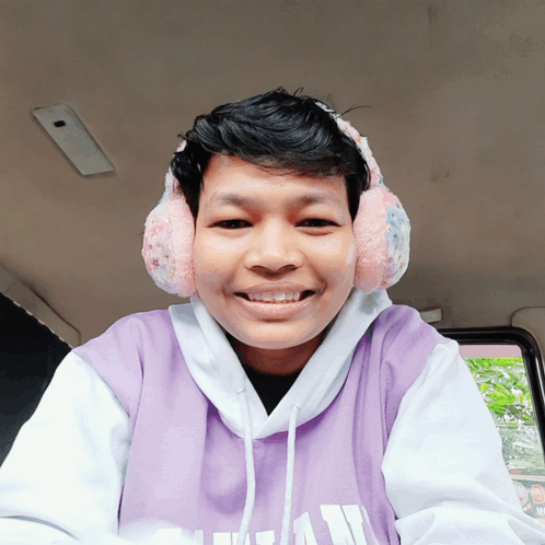 a young man wearing ear warmers and a purple shirt that says ucsd