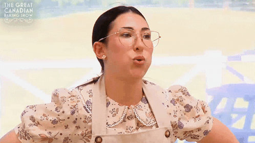 a woman wearing glasses and an apron is on a tv show called the great canadian baking show .