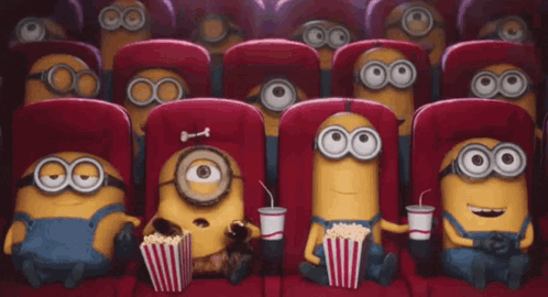 a group of minions are sitting in a theater watching a movie .