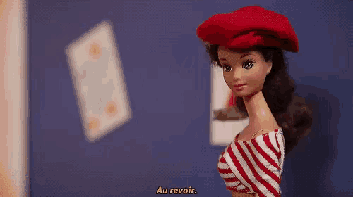 a barbie doll wearing a red beret and a striped shirt says " au revoir "
