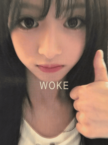 a girl is giving a thumbs up and the word woke is on her face