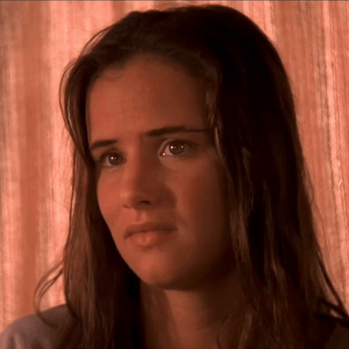 a close up of a woman 's face with a brown background