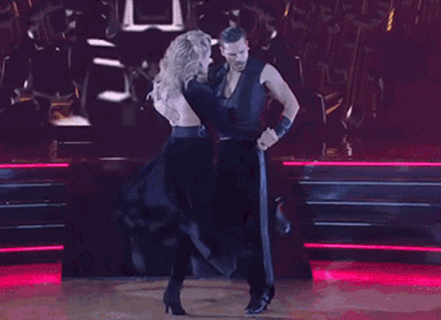 a man and a woman are dancing on a stage .