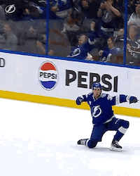 a hockey player is kneeling down in front of a pepsi sign