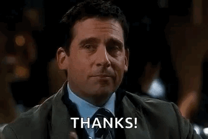 a man in a suit and tie is holding a glass of whiskey and saying `` thanks '' .