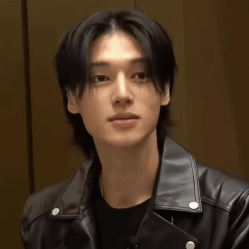 a young man wearing a black leather jacket