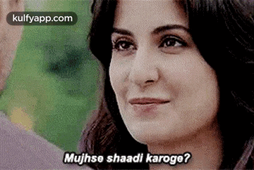 a woman is smiling and talking to a man in a movie .