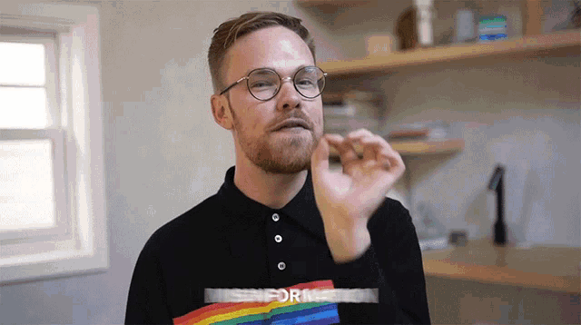 a man wearing glasses and a rainbow shirt that says misinformation on it
