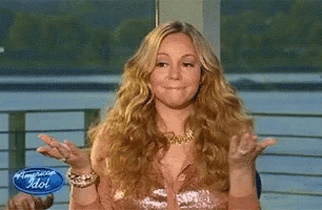 Mariah Carey shrugs with a playful “oops” expression.