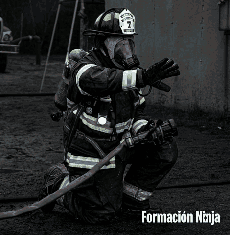 a fireman with the number 7 on his helmet is kneeling down with a hose