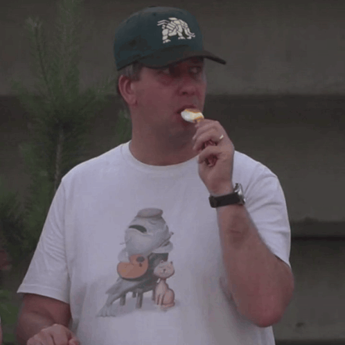 a man wearing a baseball cap with the letter m on it