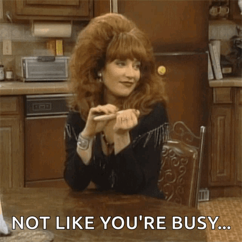 a woman with red hair is sitting at a table with the words not like you 're busy .