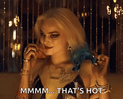 a woman in a suicide squad costume is talking on a cell phone and says mmmm ... that 's hot .
