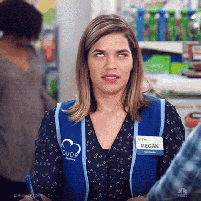 a woman in a blue vest is making a funny face .