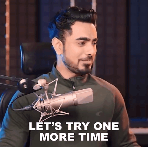 a man sitting in front of a microphone with the words let 's try one more time above him