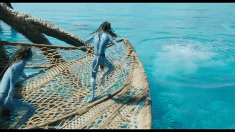 a man in a blue bodysuit is standing on a boat in the water