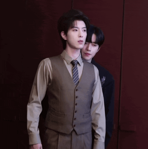 a man in a suit and tie standing next to another man