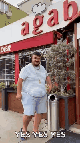 A man dances outside a storefront with “YES YES YES” text.