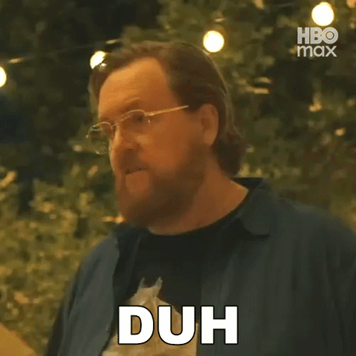 a man with a beard and glasses is making a duh sign .
