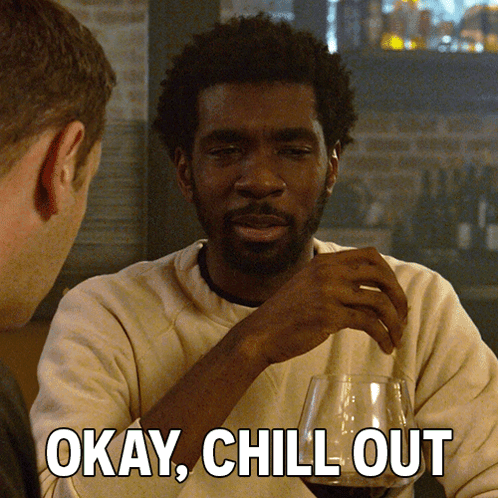 a man sitting at a table with a glass of wine and the words okay chill out above him