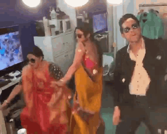 a man and two women are dancing in a room .
