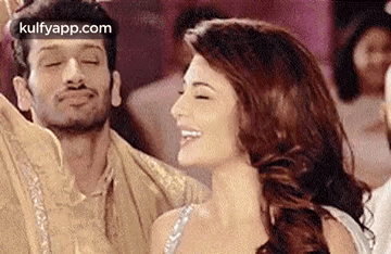 a man and a woman are dancing together at a party and smiling .