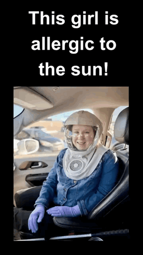 a woman is sitting in a car wearing a helmet and gloves ..