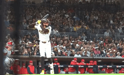 a baseball player wearing a padres jersey swings at a ball
