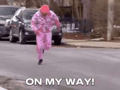 a man in a pink outfit is running down the street with the words on my way