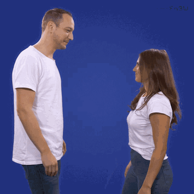 Two people on a blue backdrop prepare to high five each other.