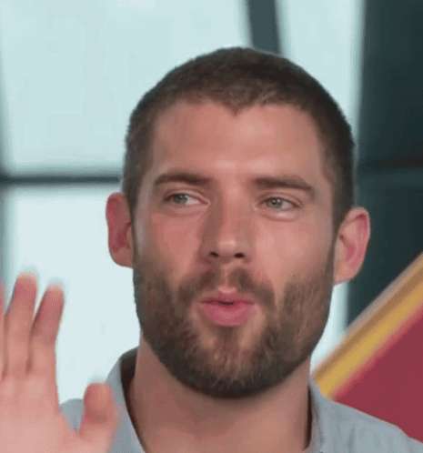 a man with a beard is making a funny face with his hand