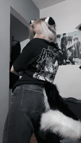 a person wearing a black shirt with a picture of a man on the wall