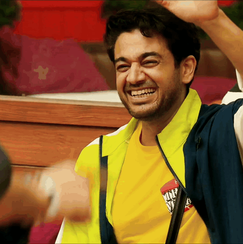 a man wearing a yellow shirt that says ' king ' on it is smiling