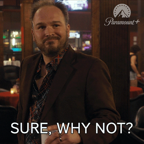 a man in a suit and tie is holding a drink and says sure why not