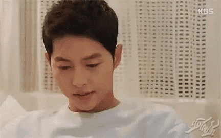 a young man is sitting in a bathtub and looking down at something .
