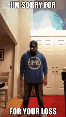 a man in a blue hoodie is standing in a room with a caption that says i 'm sorry for your loss