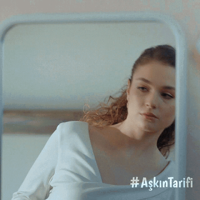 a woman is looking at herself in a mirror with the hashtag #aşkintarifi