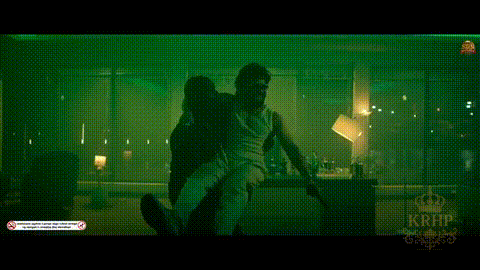 a man in a white shirt is dancing in a dark room with blue lights