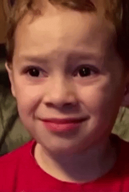 A young child gives a disappointed, teary-eyed expression.
