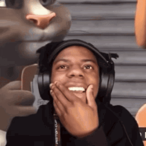 A headset-wearing streamer covers his mouth and stares in disgust.