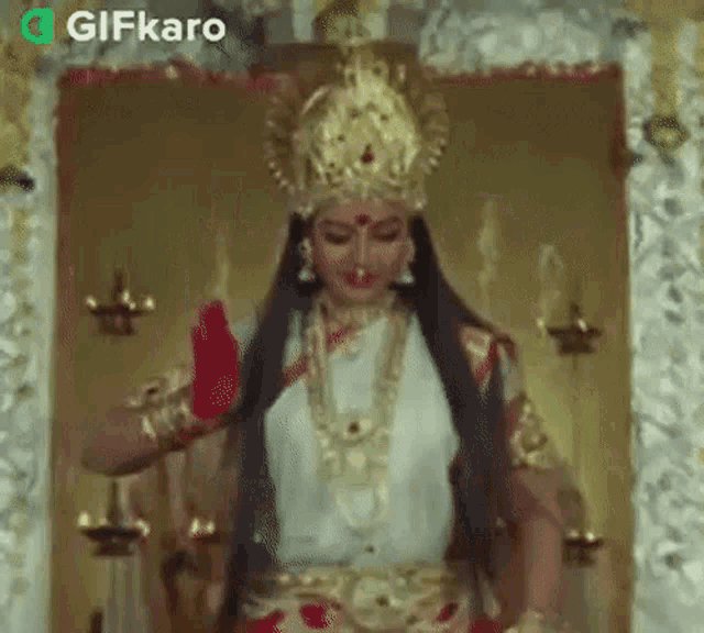 a woman dressed as a goddess is standing in front of a mirror in a temple .