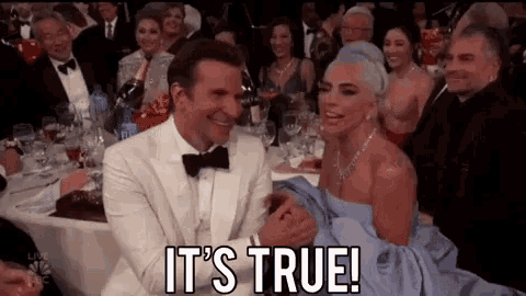 a man and a woman are sitting at a table with the words " it 's true " on the screen